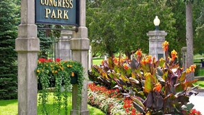 Señalización de Historic Congress Park, con un jardín al frente.