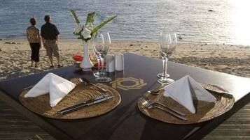 Een privéstrand, wit zand, ligstoelen aan het strand, strandlakens