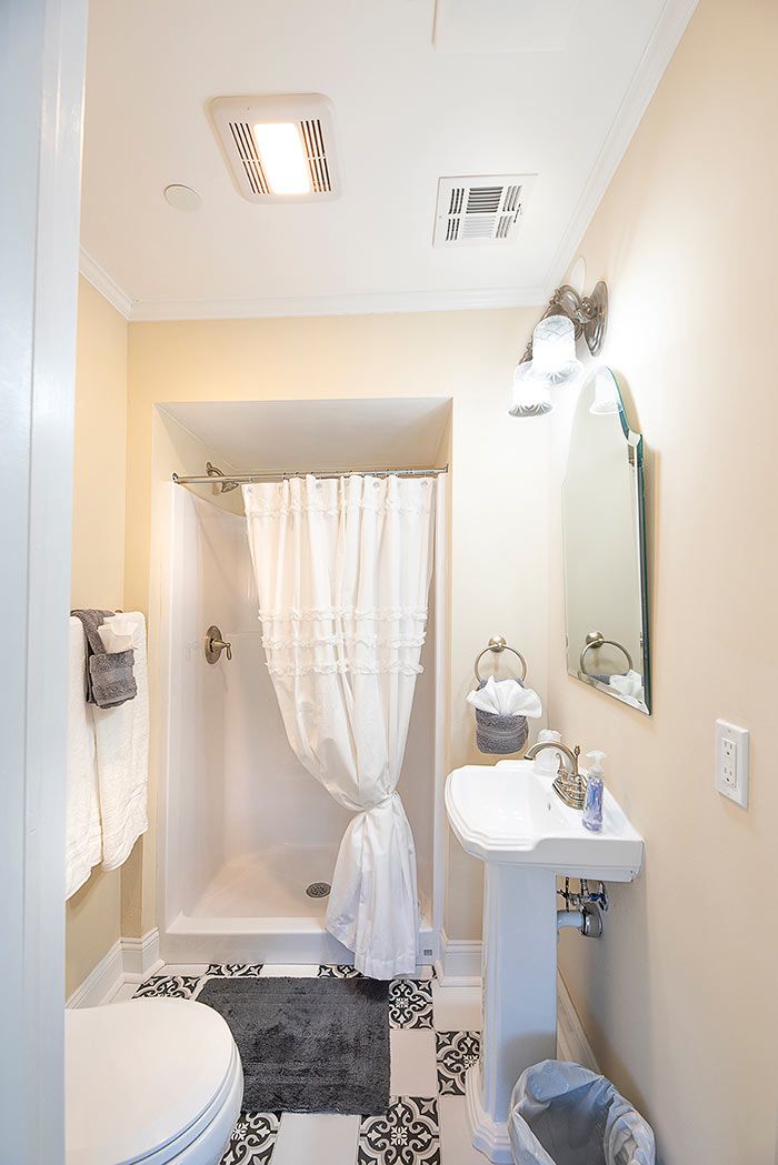 Un baño con ducha, inodoro, lavabo y espejo.