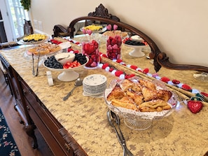 A buffet table with various food items and a decorative centerpiece. - The Carriage House B&B (Ocean Grove)