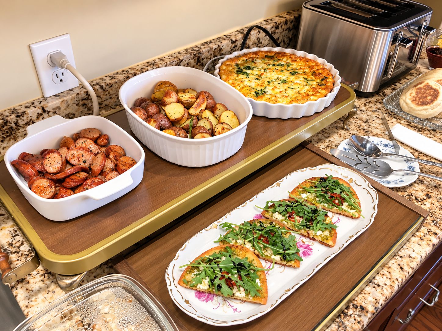 A kitchen counter with various dishes including roasted potatoes, a quiche, and pizza slices.