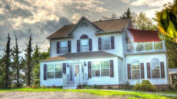 A two-story house with a porch, a red awning, and a sign that reads "The Spa."