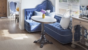 A room with a blue upholstered sofa, a round table with a vase, and a star-shaped hanging light. - Casa Laguna Hotel & Spa (Laguna Beach)