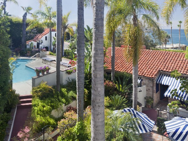 A resort with a swimming pool, palm trees, and a view of the ocean. - Casa Laguna Hotel & Spa (Laguna Beach)
