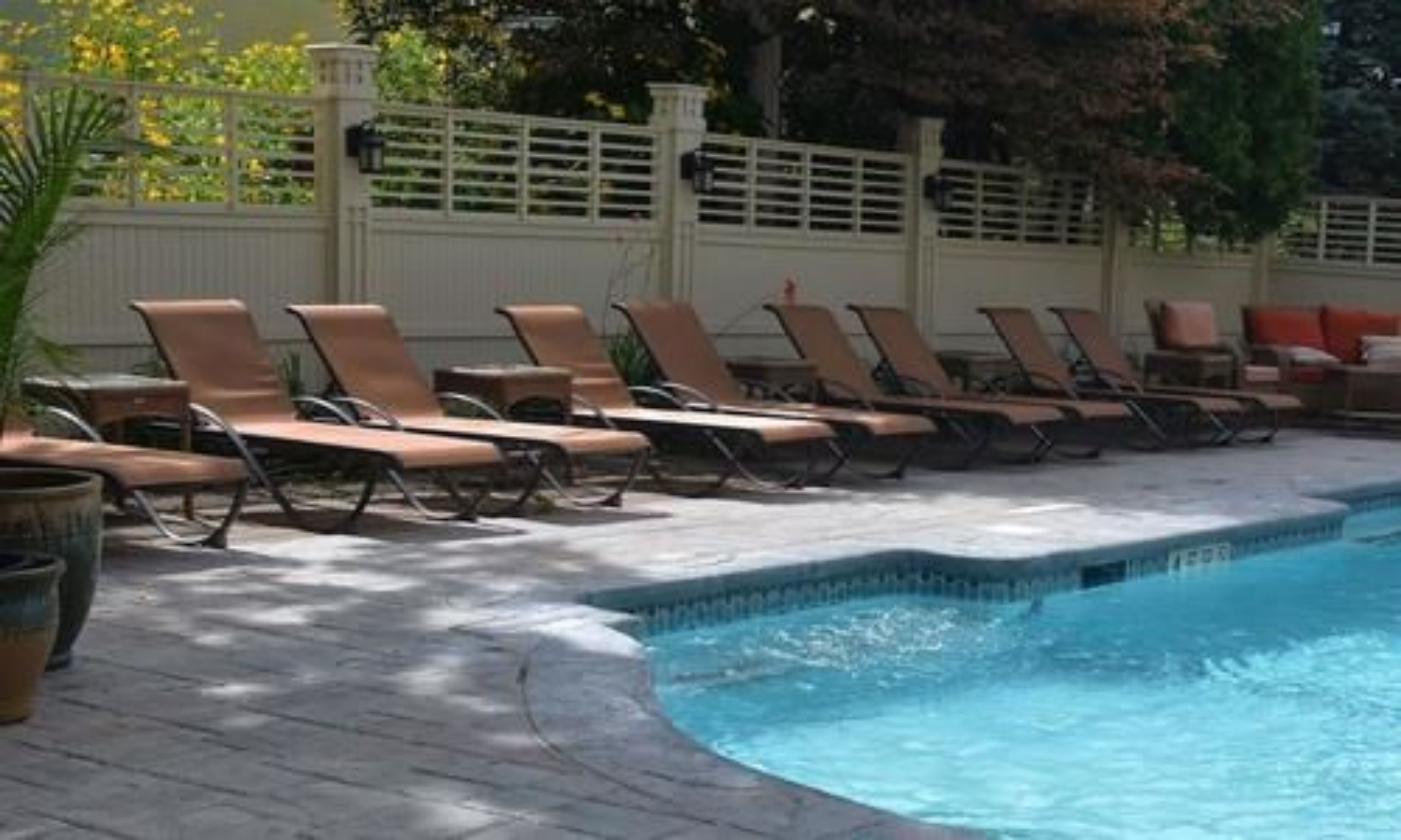A pool area with lounge chairs and a small pool.