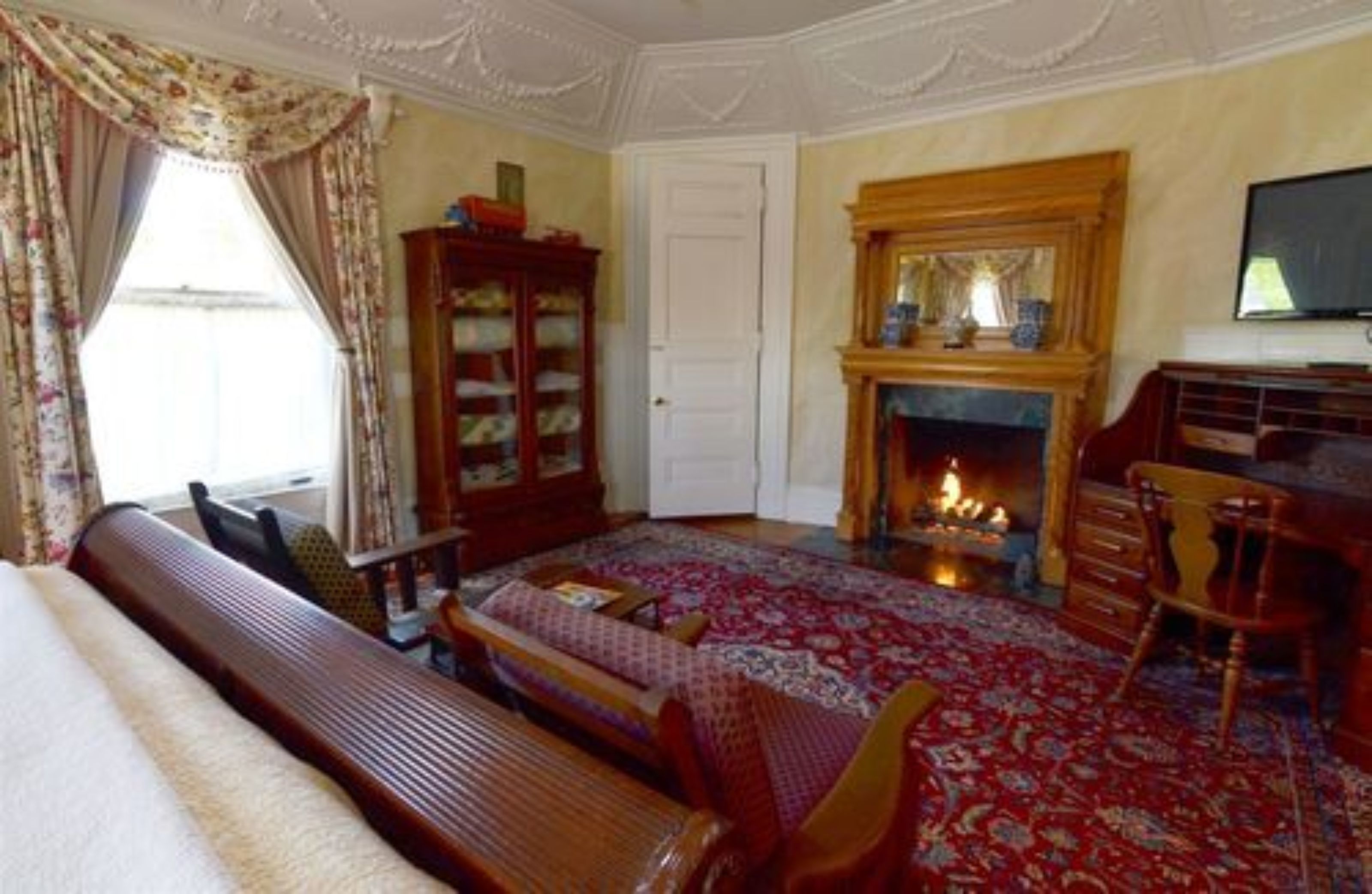 A traditional room with a fireplace, a wooden bench, and a bookshelf.