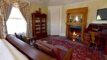 A traditional room with a fireplace, a wooden bench, and a bookshelf.