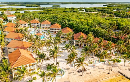 A resort with multiple buildings, a pool area, and a beach.
