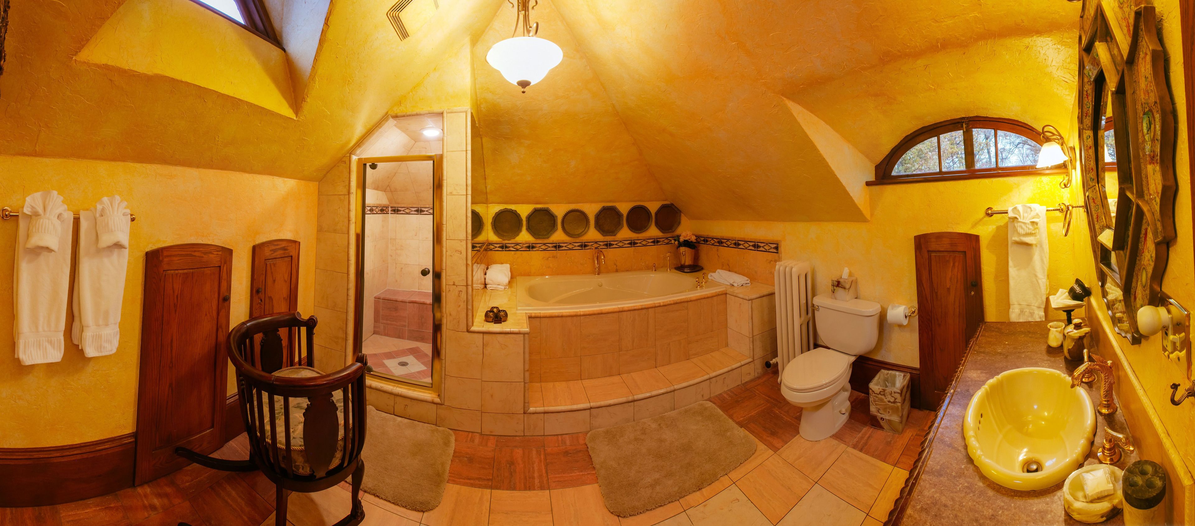 A spacious bathroom with a large bathtub, a toilet, and a sink.
