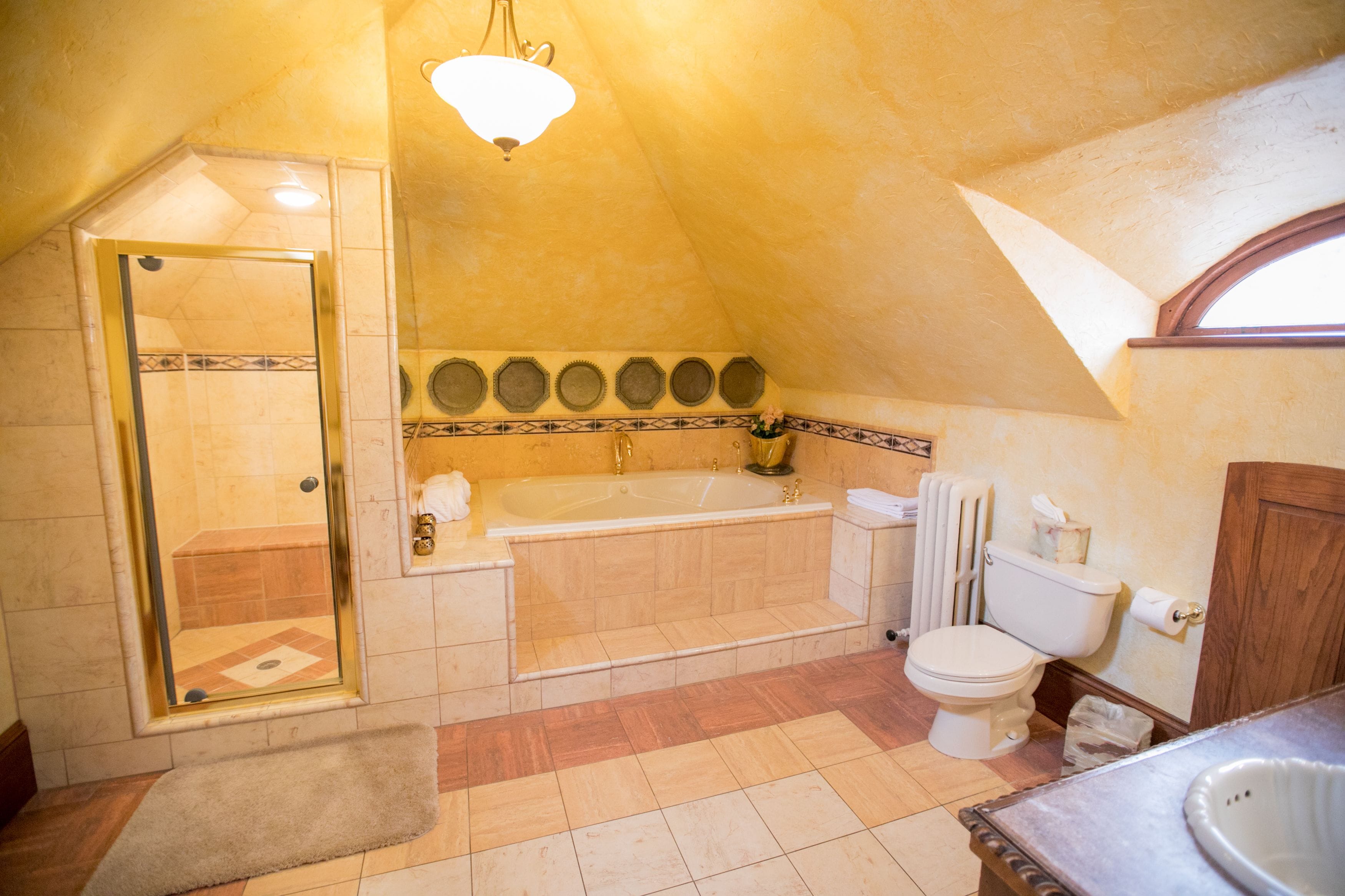 A bathroom with a bathtub, toilet, and shower area.