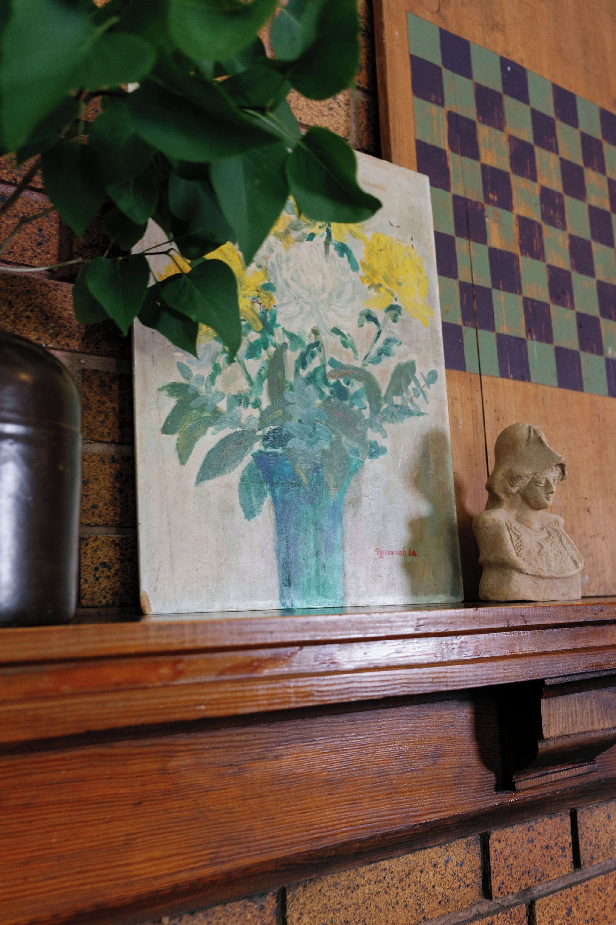 A painting of flowers in a vase on a wooden shelf.