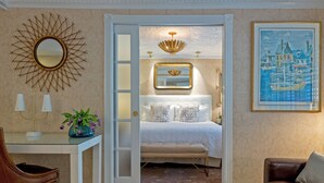Une chambre à coucher avec un lit, une table de chevet avec des lampes, un miroir et un tableau.