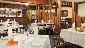 Een restaurant met houten wanden en gedekte tafels.