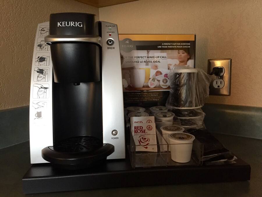Una cafetera Keurig con un soporte para cápsulas de café y una cápsula de café Keurig.