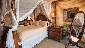 A traditional bedroom with a four-poster bed, a nightstand with a lamp, a dresser, and a mirror. - AmericInn by Wyndham Rexburg BYUI (Rexburg)