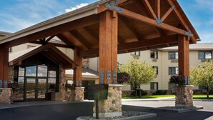 A building with a covered entrance, stone pillars, and a clear sky. - AmericInn by Wyndham Rexburg BYUI (Rexburg)