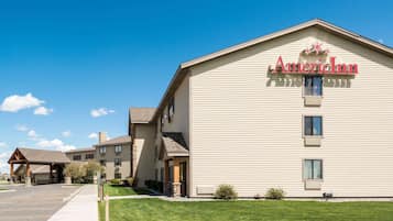 A two-story building with the sign "AmericInn" on the facade, a covered entrance, and a parking lot in front.