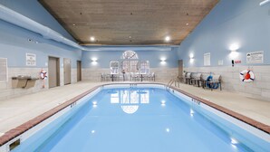 A large indoor swimming pool with a wooden ceiling, lifeguard chairs, and safety signs. - Holiday Inn Express & Suites Zion by IHG (Zion)