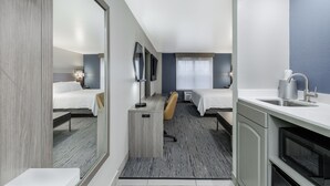 A hotel room with a bed, desk, chair, and a kitchenette. - Holiday Inn Express & Suites Zion by IHG (Zion)