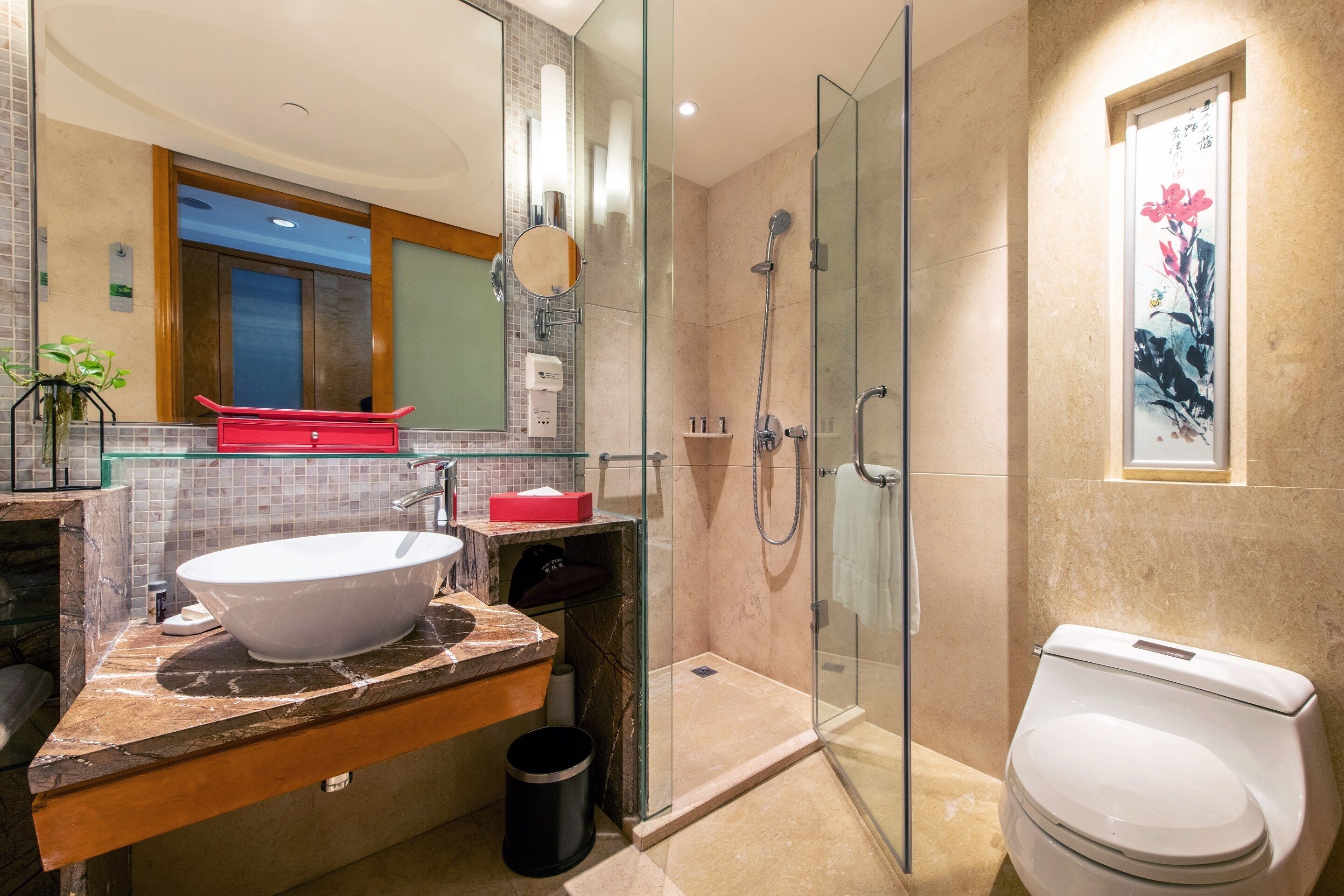 Une salle de bain moderne avec une douche à parois de verre, un lavabo blanc et des toilettes.
