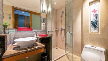 A modern bathroom with a glass-enclosed shower, a white sink, and a toilet.