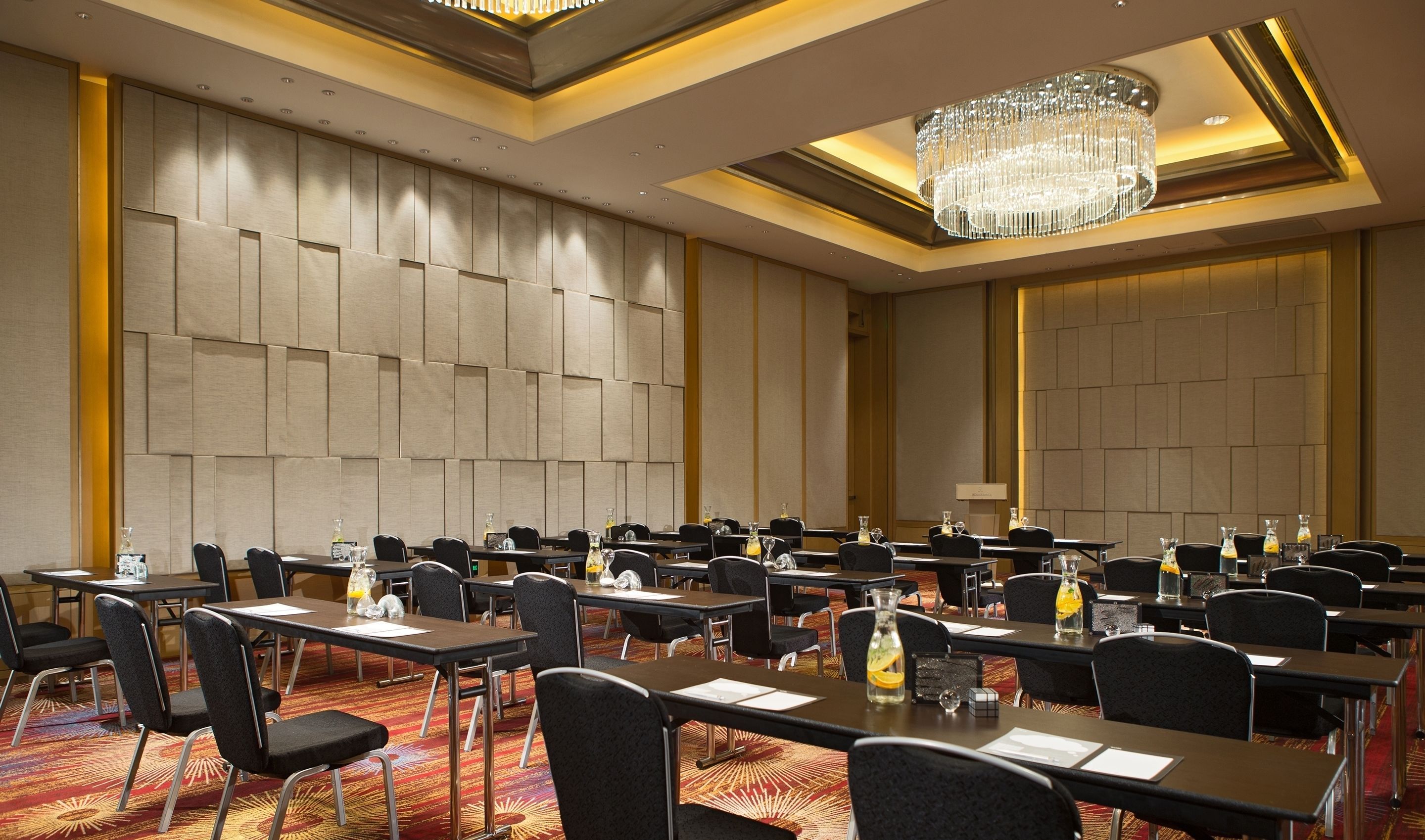 A conference room with multiple tables and chairs, equipped with nameplates and water bottles.