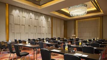 A conference room with multiple tables and chairs, equipped with nameplates and water bottles.