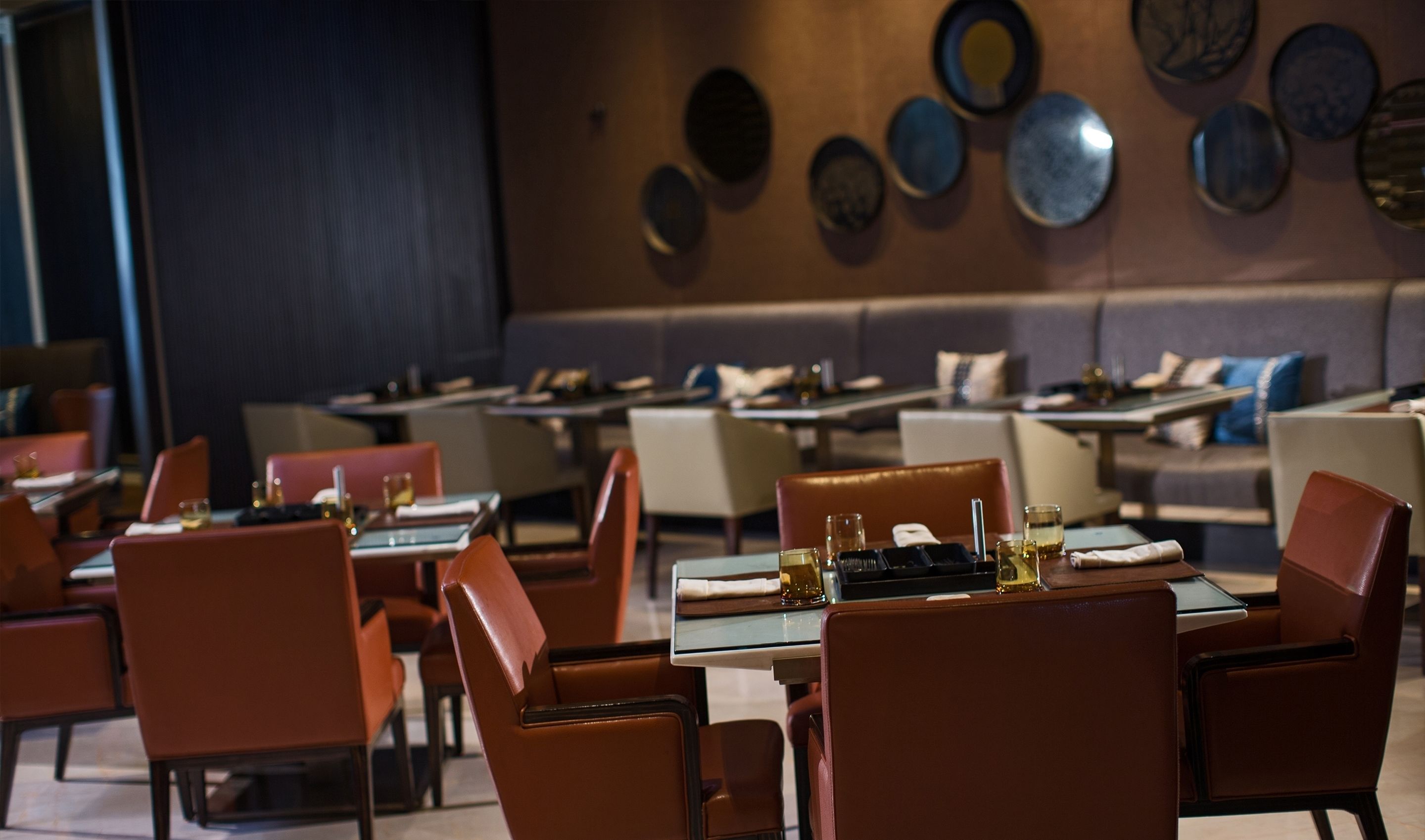 Un restaurant amb taules preparades per dinar, amb un interior modern i una combinació d'opcions de seients.