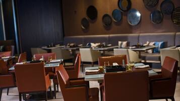 Un restaurant amb taules preparades per dinar, amb un interior modern i una combinació d'opcions de seients.