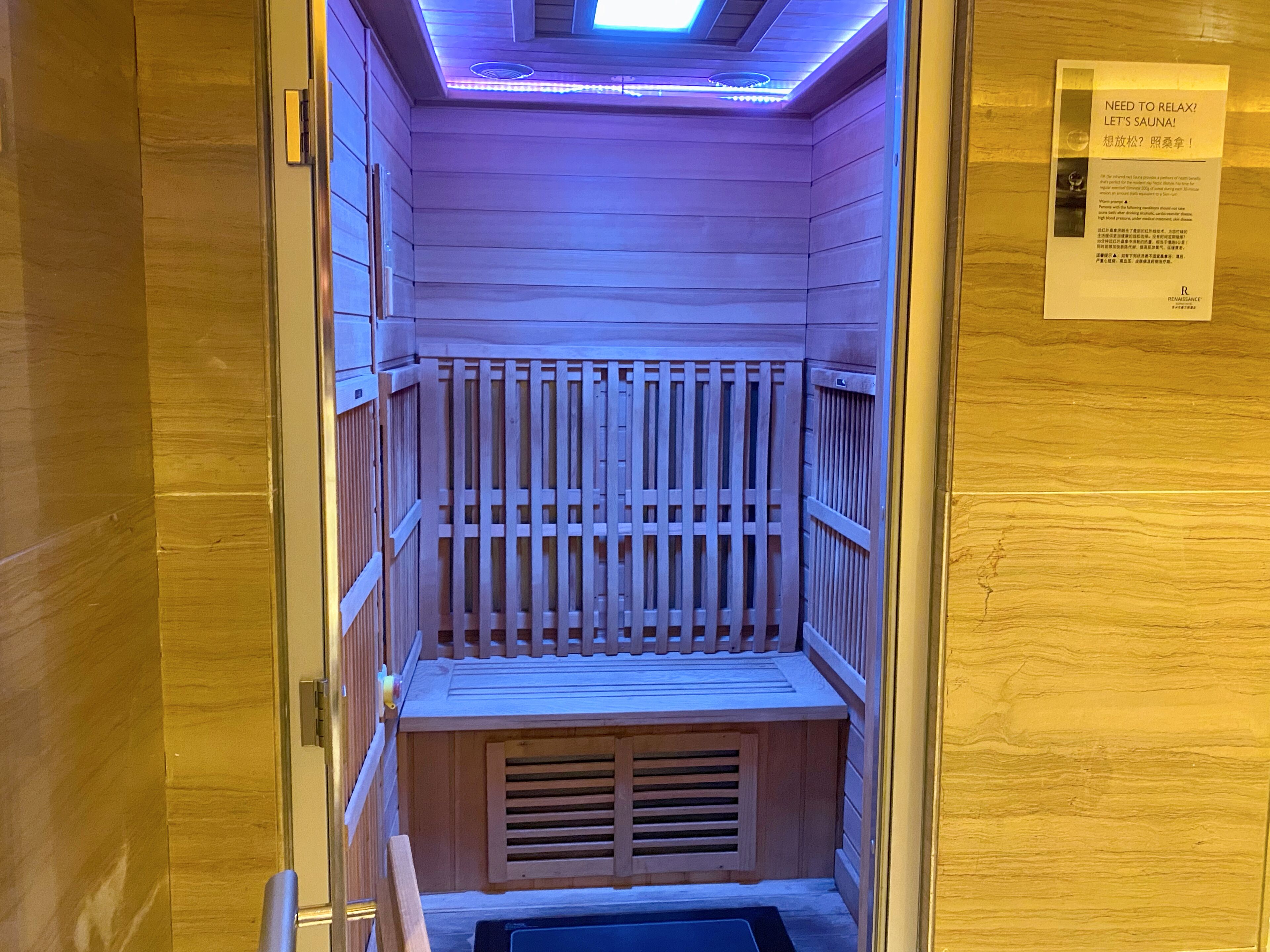 A sauna room with wooden slats and a bench.