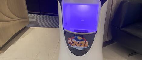A white, stationary exercise machine with a digital display and a blue light inside.