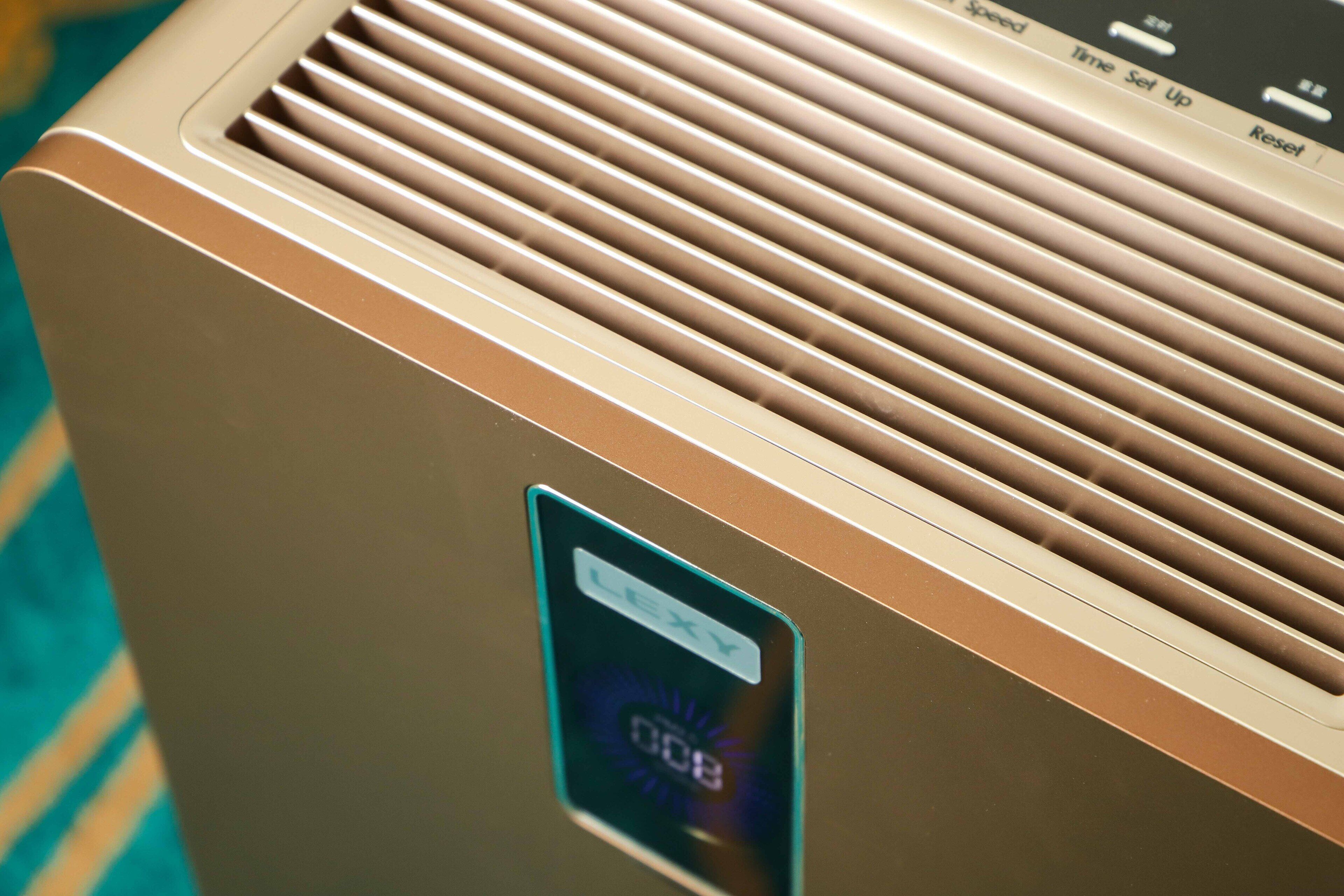 A close-up of a metallic air conditioning unit with a digital display and control panel.
