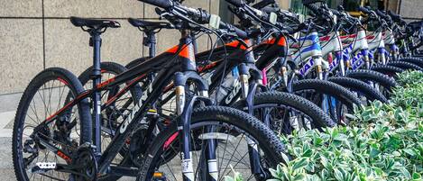 A row of bicycles parked against a building wall.