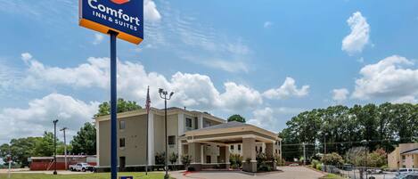 A Comfort Inn & Suites with a large sign, a covered entrance, and a parking lot.