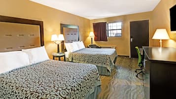Quarto de hotel com duas camas, uma escrivaninha, uma cadeira e uma televisão.