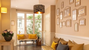 Un interior moderno con un sofá, un banco y una pared decorada con obras de arte enmarcadas.