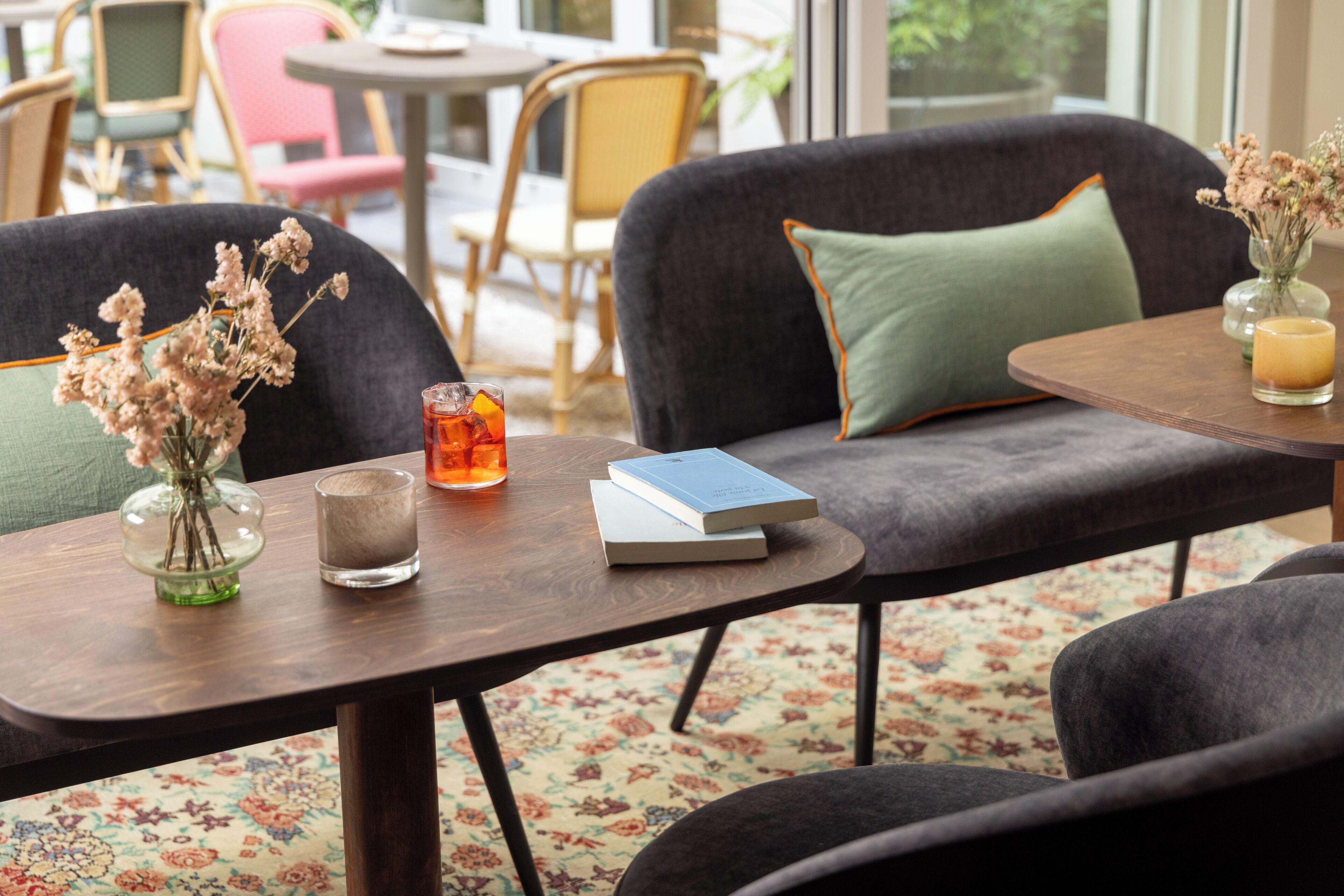 A cozy seating area with a table, chairs, and a vase of flowers.