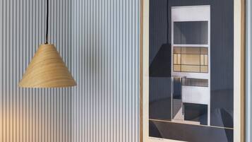 Een ingelijste architectuurtekening aan een muur met een hangende, kegelvormige hanglamp.