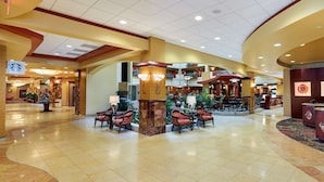 A spacious lobby with a central seating area, a reception desk, and multiple levels with balconies. - Embassy Suites by Hilton Hampton Convention Center (Hampton)