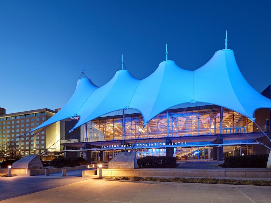 Un centro de convenciones con una arquitectura moderna distintiva, que cuenta con una gran estructura de techo curva.