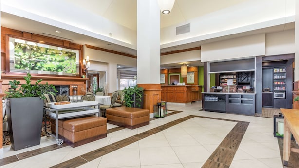 Een ruime lobby met een zithoek, een receptiebalie en een kitchenette.