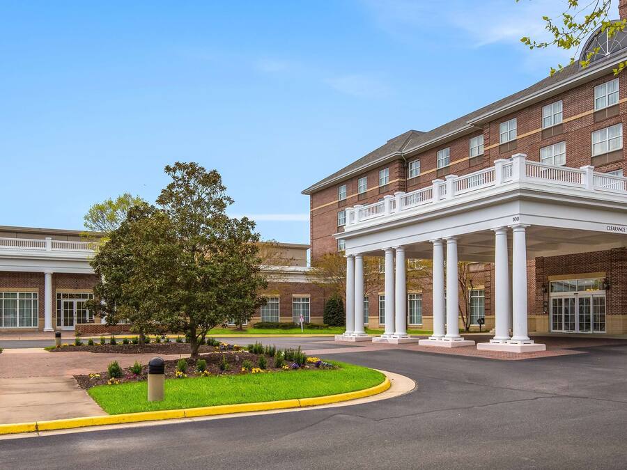 A brick building with a covered entrance and a landscaped garden area.