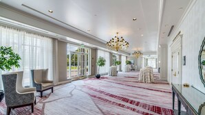 A spacious hotel lobby with a red and white carpet, large windows, and a chandelier. - Hilton Garden Inn Suffolk Riverfront (Suffolk)