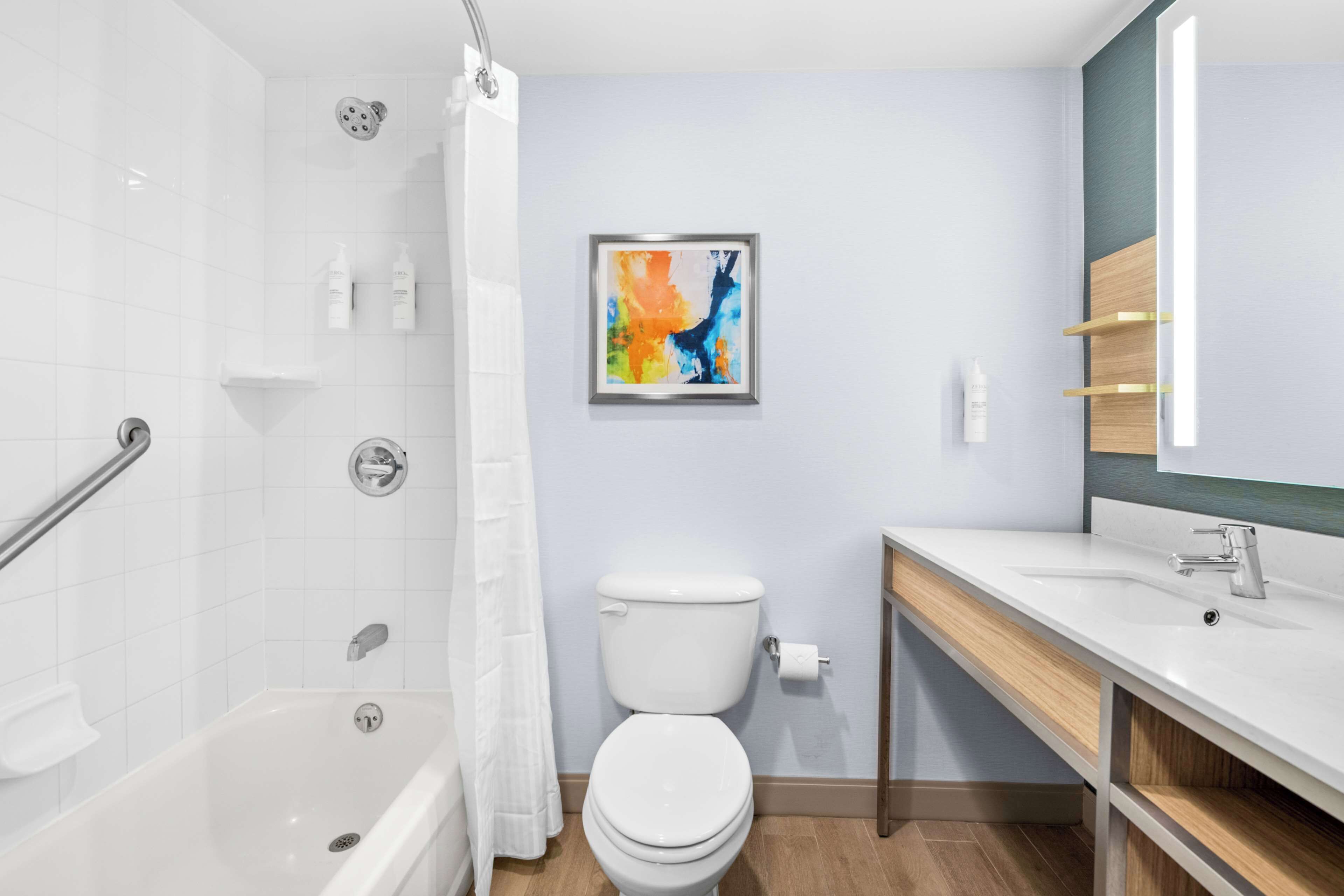 A modern bathroom with a shower, toilet, and sink.