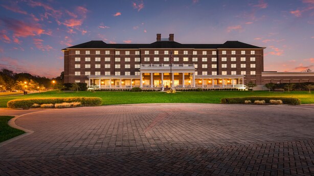 A large hotel with a central courtyard, multiple floors, and a well-lit entrance. - Hilton Garden Inn Suffolk Riverfront (Suffolk)