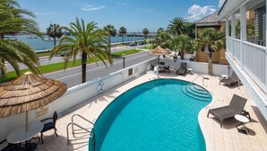 A pool area with a view of the marina, palm trees, and a building with a white exterior. - Hilton St. Augustine Historic Bayfront (St. Augustine)