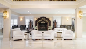 A spacious lobby with white sofas, a fireplace, and ornate gold detailing on the ceiling. - Hilton St. Augustine Historic Bayfront (St. Augustine)