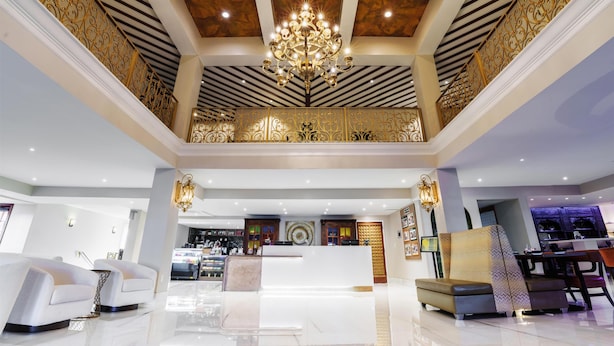 A hotel lobby with a chandelier, seating area, reception desk, and a view of the reception area. - Hilton St. Augustine Historic Bayfront (St. Augustine)