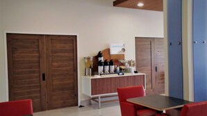 A room with a wooden door, a white counter with kitchen appliances, and red chairs. - Holiday Inn Express Hotel & Suites Tampa-Fairgrounds-Casino by IHG (Tampa)