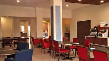 A modern dining area with red and blue chairs, wooden tables, and a counter with a sign reading "Smart Roast".